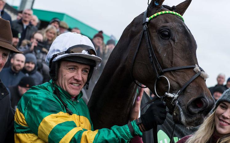 A Jockey celebrates his run with horse and training staff