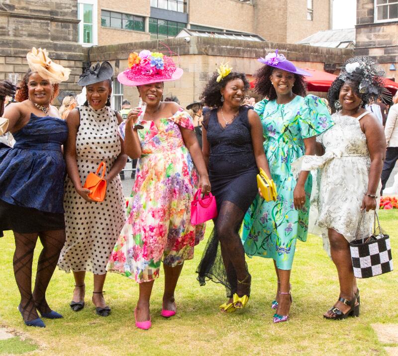 A group of ladies dressed for the races on the lawn at Newcastle Racecourse