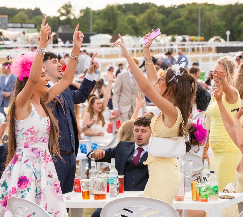 A group singing and dancing at their table at Newcastle Races