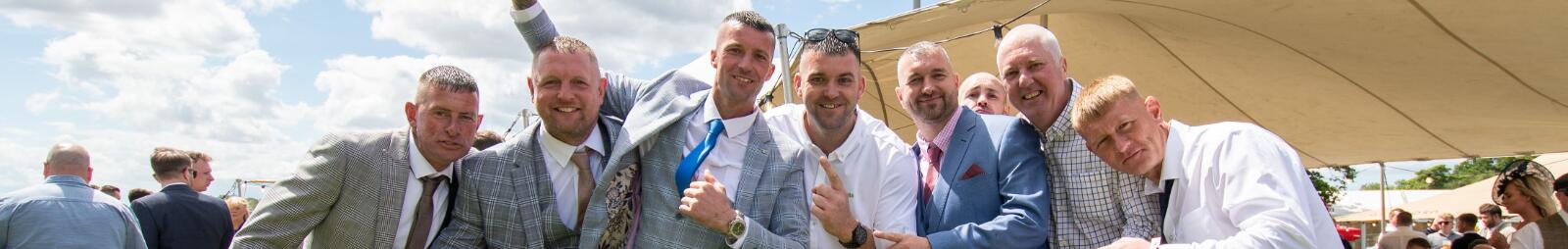 A large group of guys celebrating at Newcastle Races