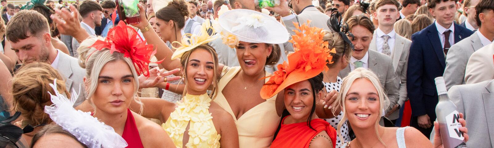 A group of brightly dressed ladies in the crowd at Newcastle Races