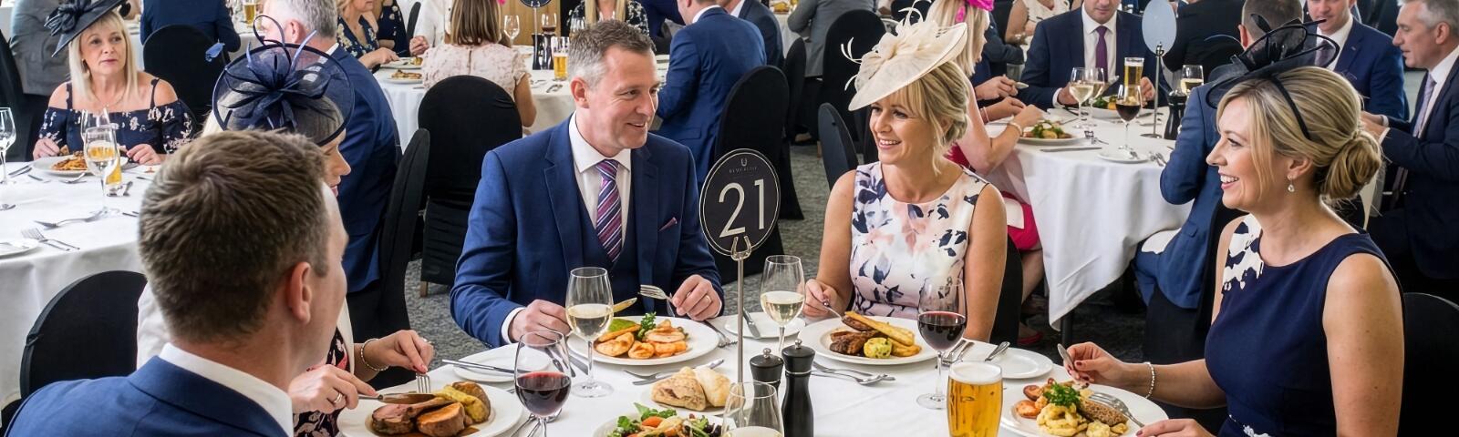 Group of people sitting at a table, enjoying their food.