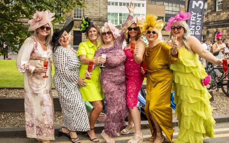 A group of ladies at Newcastle Racecourse in brightly coloured outfits